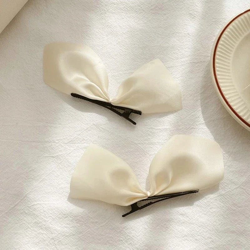 Deux PINCE À CHEVEUX PLATE | SatinBow™ - Blanc en vedette sur une table en présentation de sa beauté