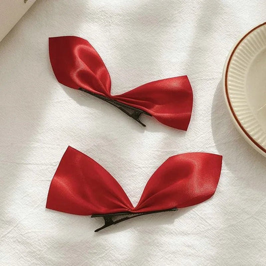 PINCE À CHEVEUX PLATE | SatinBow™ - Rouge, sur une table et présentation de la pince cheveux plate qui la compose.
