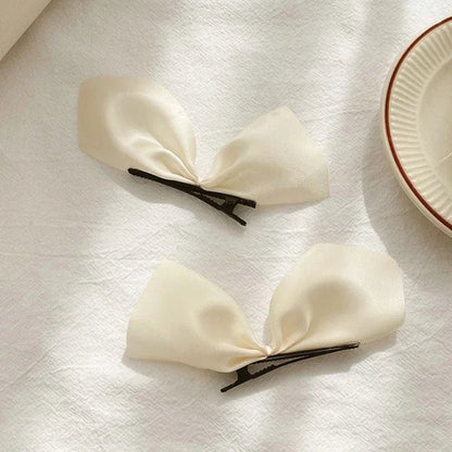 Deux PINCE À CHEVEUX PLATE | SatinBow™ - Blanc en vedette sur une table en présentation de sa beauté