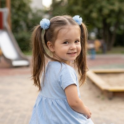 Elastique cheveux sur la tete d'une petite fille dans un aire de jeux